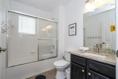 a bathroom with a shower and a toilet and a sink at Condo 4Q Seven Dwarfs Resort - Perto da Disney in Kissimmee