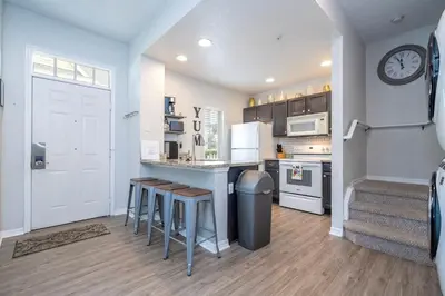 a kitchen with a counter and stools in a room at Condo 4Q Seven Dwarfs Resort - Perto da Disney in Kissimmee