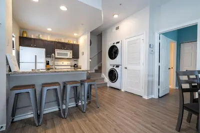 a kitchen with a counter and bar stools at Condo 4Q Seven Dwarfs Resort - Perto da Disney in Kissimmee