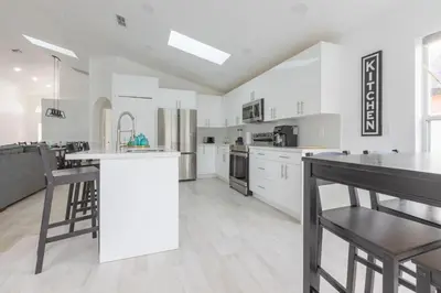a large kitchen with white cabinets and a counter top at Resort-Style Home Near Disney | Pool | Game Room in Kissimmee