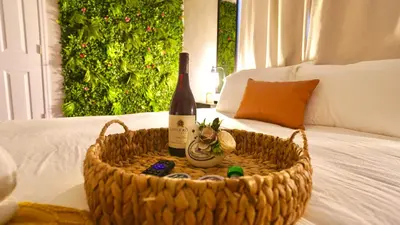 a bottle of wine in a basket on a bed at Quiet Boho Suite near Orlando attractions in Orlando