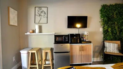 a small kitchen with a refrigerator and a microwave at Quiet Boho Suite near Orlando attractions in Orlando