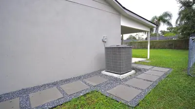 a stone walkway next to a white house at Quiet Boho Suite near Orlando attractions in Orlando