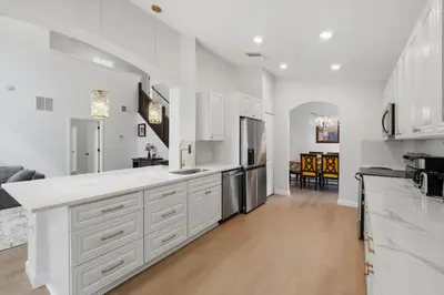 a kitchen with white cabinets and a large white counter top at The Seasons Retreat 5BR Oasis with Private Pool in Kissimmee
