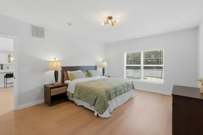a white bedroom with a bed and a window at The Seasons Retreat 5BR Oasis with Private Pool in Kissimmee