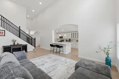 a living room with a couch and a kitchen at The Seasons Retreat 5BR Oasis with Private Pool in Kissimmee