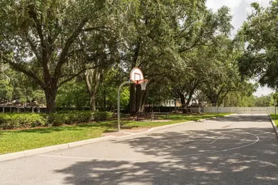 a basketball hoop in a park with trees at Casa 4Q Moderna em Lucaya Village Kissimmee in Kissimmee