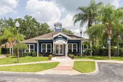 a blue house with palm trees in front of it at Casa 4Q Moderna em Lucaya Village Kissimmee in Kissimmee