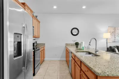 a kitchen with a refrigerator and a sink at Townhome 4Q Storey Lake - 10 min Disney in Kissimmee