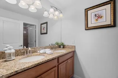 a bathroom with two sinks and a large mirror at Townhome 4Q Storey Lake - 10 min Disney in Kissimmee