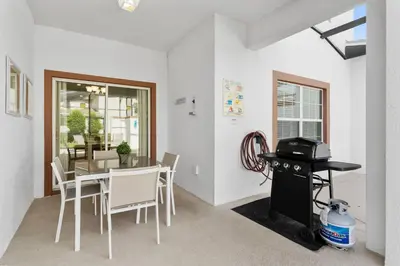 a dining room with a table and white chairs at Townhome 4Q Storey Lake - 10 min Disney in Kissimmee