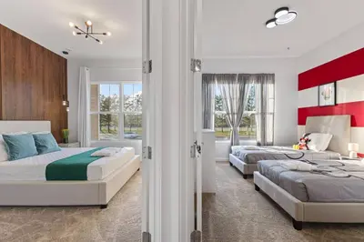 two beds in a bedroom with red and white at 5 Suites Sleeps 14 Lion King Mickey Theme in Orlando