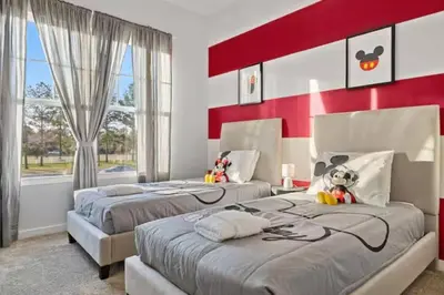 two beds in a bedroom with red and white walls at 5 Suites Sleeps 14 Lion King Mickey Theme in Orlando