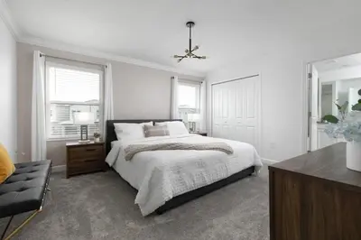 a white bedroom with a bed and a chair at Casa 4Q Chic Storey Lake - Perto Disney in Kissimmee