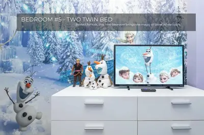 a television on a dresser with penguins and snow at 5BRDisney Villa Pool,Game Room & Resort Access in Kissimmee