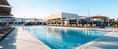 a large swimming pool with chairs and umbrellas at 4BR Disney Area Townhome - Pool, Grill & Clubhouse in Orlando
