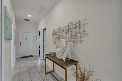a hallway with a white wall with a sculpture on it at Kingdoms and Galaxies Luxury Villa in Kissimmee