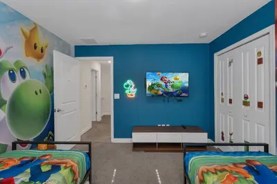 a room with two beds and a blue wall at Kingdoms and Galaxies Luxury Villa in Kissimmee