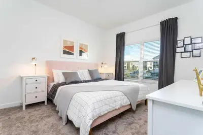 a white bedroom with a bed and a window at Townhome 4Q Storey Lake - Piscina & Temas in Kissimmee
