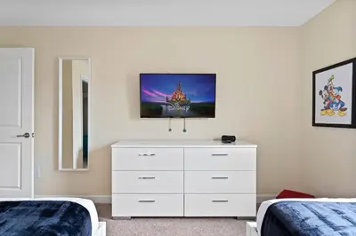 a bedroom with two beds and a white dresser at Casa 4Q Storey Lake - Piscina Privativa in Kissimmee