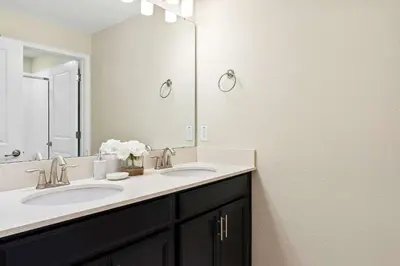 a bathroom with two sinks and a large mirror at Casa 4Q Storey Lake - Piscina Privativa in Kissimmee