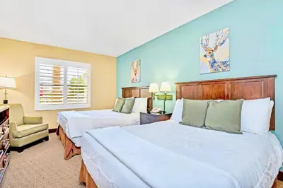 a hotel room with two beds and a chair at Condo w Hot Tub & Pool - Steps to Universal Studio in Orlando