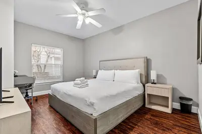 a bedroom with a bed with a ceiling fan and a desk at Near Disney! Kissimmee Home for 12 w/ Pool Access! in Kissimmee