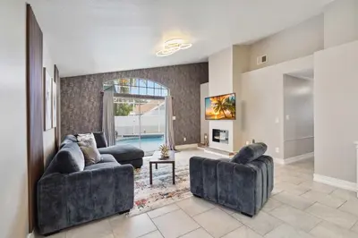 a living room with two couches and a pool at Disney Heated Pool & Arcade Home 15 mins to Park in Kissimmee