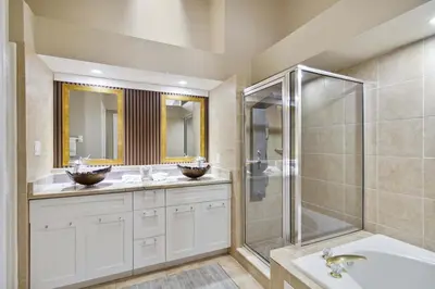a bathroom with two sinks and a shower at Disney Heated Pool & Arcade Home 15 mins to Park in Kissimmee