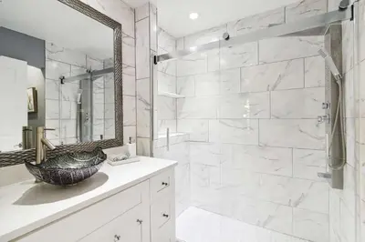 a bathroom with a shower with a sink and a mirror at Disney Heated Pool & Arcade Home 15 mins to Park in Kissimmee