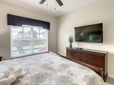 a bedroom with a large bed and a flat screen tv at Holiday Home Familien-Pool-Rückzug nur 2-5 Meilen von Disney entfernt by Interhome in Kissimmee