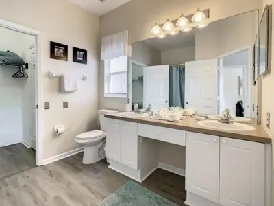a white bathroom with a toilet and a sink at Holiday Home Familien-Pool-Rückzug nur 2-5 Meilen von Disney entfernt by Interhome in Kissimmee