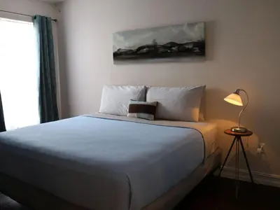a bedroom with a white bed with a lamp and a painting at Apartment Orlando Condo in der Nähe von Disney- Schläft 8 by Interhome in Kissimmee