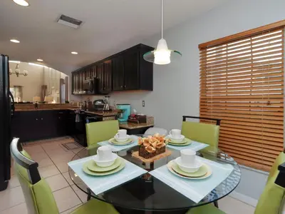 a dining room with a table and chairs and a kitchen at Holiday Home Villa mit 6 Schlafzimmern und atemberaubendem Seeblick by Interhome in Kissimmee
