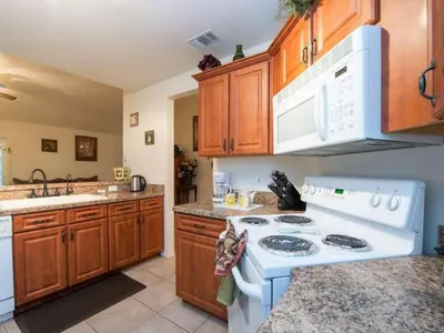 a kitchen with a white stove and wooden cabinets at Holiday Home Ausgezeichnetes Preis-Leistungs-Verhältnis Familienvilla - Süd-West Privater Po by Interhome in Kissimmee