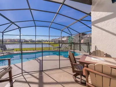 a patio with a pool and a table and chairs at Holiday Home Moderne Villa mit Seeblick nur wenige Minuten von Disney entfernt by Interhome in Kissimmee