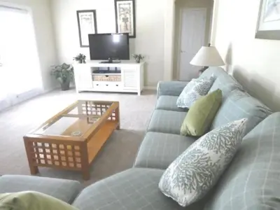 a living room with a blue couch and a coffee table at Holiday Home 3-Schlafzimmer Value Plus Haus mit privatem Pool by Interhome in Kissimmee