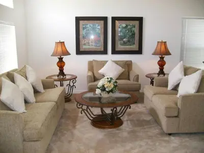 a living room with two couches and a table at Holiday Home 3-Schlafzimmer Value Plus Haus mit privatem Pool by Interhome in Kissimmee