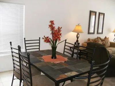 a dining room table with a vase of flowers on it at Holiday Home 3-Schlafzimmer Value Plus Haus mit privatem Pool by Interhome in Kissimmee