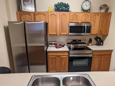 a kitchen with stainless steel appliances and wooden cabinets at Apartment Wasserpark Fantastischer Pool Nur wenige Minuten von Disney Parks entfernt by Interhome in Orlando