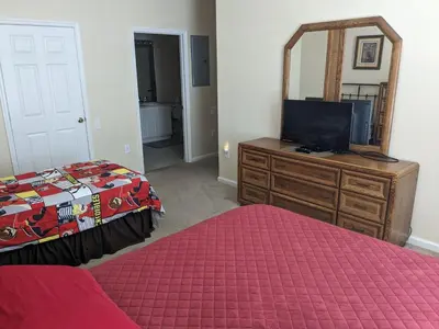 a bedroom with a bed and a dresser with a mirror at Apartment Wasserpark Fantastischer Pool Nur wenige Minuten von Disney Parks entfernt by Interhome in Orlando
