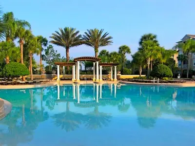 a large swimming pool with trees and blue water at Apartment Wasserpark Fantastischer Pool Nur wenige Minuten von Disney Parks entfernt by Interhome in Orlando