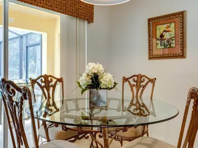 a glass dining room table with chairs and a vase of flowers at Holiday Home Luxuriöse 4-Bett-Villa in Disney by Interhome in Kissimmee