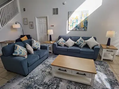 a living room with two blue couches and a table at Holiday Home Seasons Retreat mit privatem Pool in der Nähe von Disney by Interhome in Kissimmee