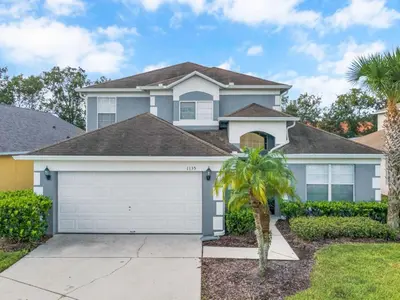 a house with a garage and a palm tree at Holiday Home Seasons Retreat mit privatem Pool in der Nähe von Disney by Interhome in Kissimmee