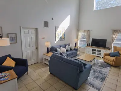 a living room with blue couches and a tv at Holiday Home Seasons Retreat mit privatem Pool in der Nähe von Disney by Interhome in Kissimmee