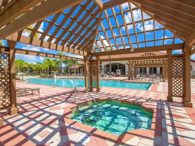 an indoor pool with a large wooden pavilion with a large swimming pool at Holiday Home Florida Breeze mit Whirlpool by Interhome in Kissimmee