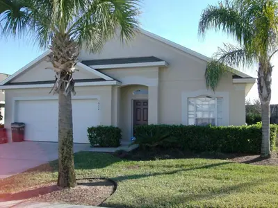 a house with palm trees in front of it at Holiday Home Villa Glenbrook Resort by Interhome in Orlando