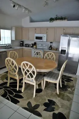 a kitchen with a wooden table and chairs and a refrigerator at Holiday Home Familienfreundliche Villa nahe der Disney-Parks by Interhome in Orlando