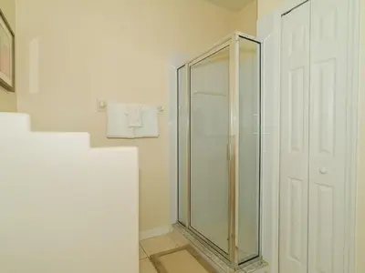 a glass shower in a bathroom with a white door at Holiday Home Ruhige Glenbrook-Flucht in der Nähe von Disney by Interhome in Orlando
